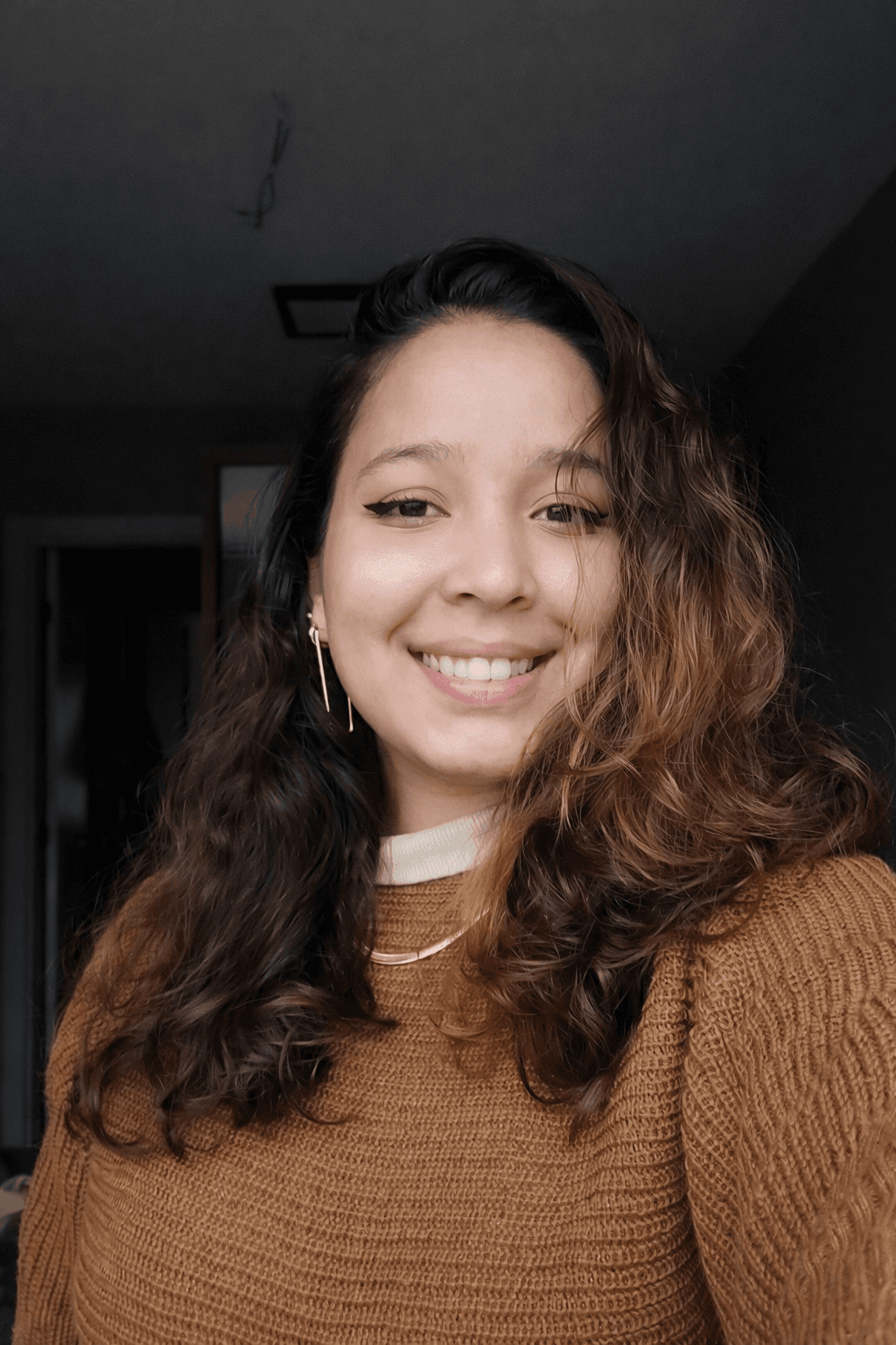 Smiling woman learning Portuguese on laptop